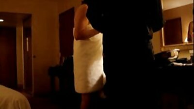En brunett med en kinky blick i ansiktet onanerar på sängen